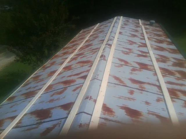 Rusted metal roof panels with new wood purlins before replacement — Storm Damage Roof Repair in Bryant by Roofing Brothers