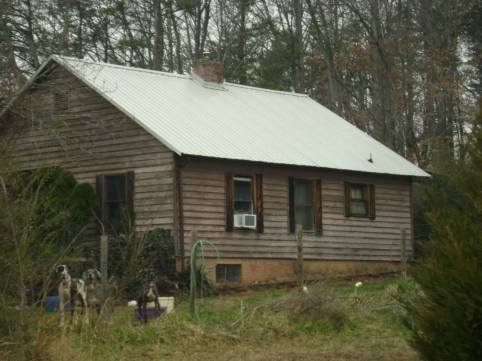 White metal roof on an old wood sided farmhouse, from a Asphalt Shingle Roof Repair job in Bryant